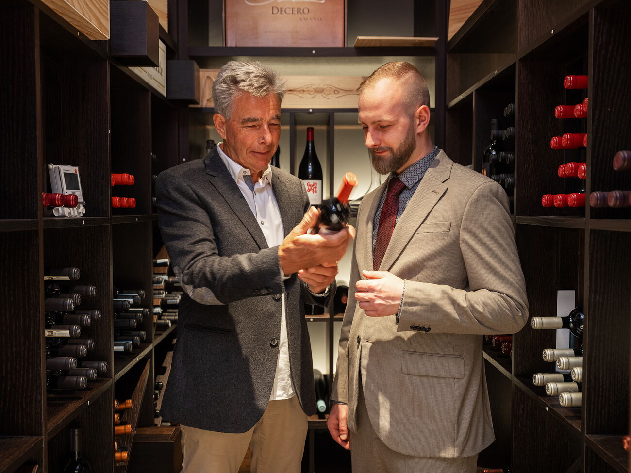 Restaurant Acasa Weinkeller: Ein Kellner zeigt dem Gast eine Flasche Wein