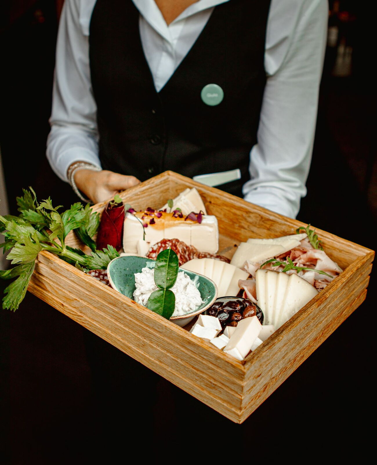 Banquet detail of a wooden plate with freshly sliced cheese